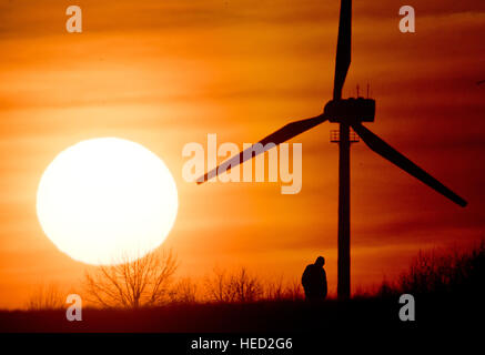 Hannover, Germania. Xxi Dec, 2016. Meteo. Un uomo che cammina su un campo come il sole tramonta sull'orizzonte il 21 dicembre 2016 - il giorno più corto dell'anno - vicino ad Hannover in Germania. Dal 21 dicembre, il solstizio d'inverno, le notti saranno iniziano ad accorciarsi e i giorni diventerà più lungo. Credito: dpa picture alliance/Alamy Live News Foto Stock