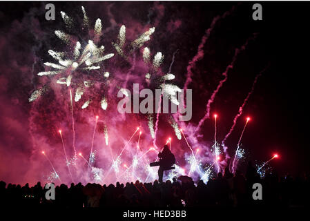 Brighton, Sussex, Regno Unito. Xxi Dec, 2016. Uno spettatore ottiene una buona vista dei fuochi d'artificio finale a la masterizzazione annuale gli orologi lanterna processione e fuochi in Brighton questa sera. L evento è organizzato dalla stessa Sky community arts carità per celebrare il solstizio d'inverno e per riflettere sull'anno andato da © Simon Dack/Alamy Live News Foto Stock