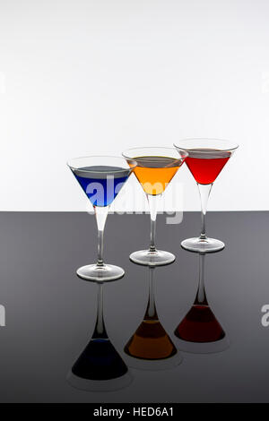 Cocktail colorati in bicchieri da Martini sfondo. Bar spot concetto. Foto Stock
