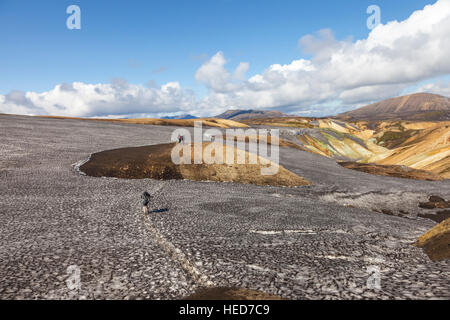 Hikers Crossing Volcanic Ash Blackened Snow Fields on the Laugavegur Hiking Trail Iceland Foto Stock