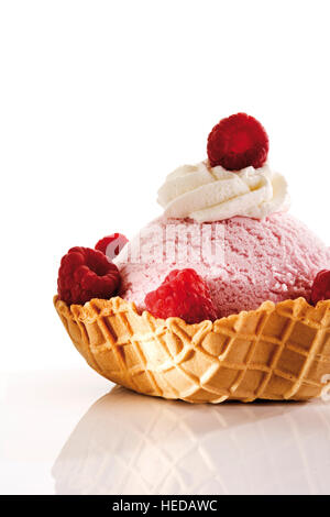 Gelato al lampone, panna montata e lamponi in una ciotola di wafer Foto Stock