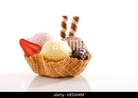 Fragola, vaniglia e gelato al cioccolato, pralina e rotoli di wafer in una ciotola di wafer Foto Stock