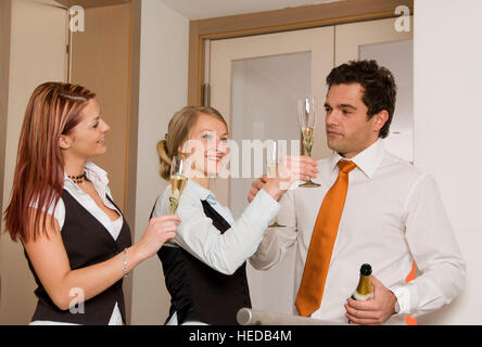 Tre giovani imprenditori con vino spumante bicchieri, di tostatura Foto Stock