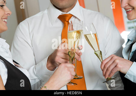 Tre gli imprenditori di bere vino spumante, bicchieri tintinnanti Foto Stock