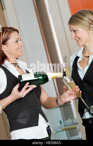 Due giovani donne di bere vino spumante Foto Stock