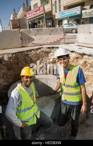 Lavoratori assistono nell'urbano linea di galleggiamento la costruzione in Zarqa, Giordania. Foto Stock