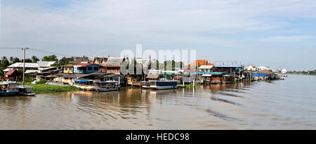 Modesto stili di vita con le case su palafitte lungo le rive del Fiume Chao Phraya a Bangkok, in Thailandia Foto Stock