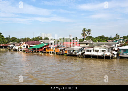 Modesto stile di vita con le case su palafitte lungo le rive del Fiume Chao Phraya a Bangkok, in Thailandia Foto Stock