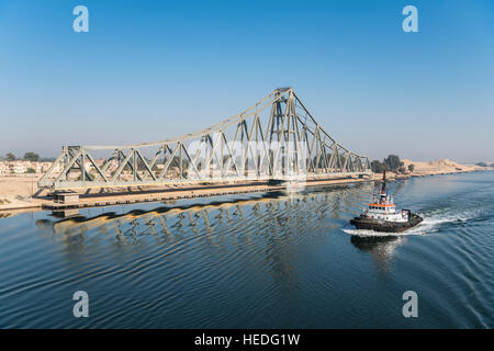 Rimorchiatore passa El Ferdan ponte ferroviario nel Canale di Suez vicino a Ismailia, Egitto Foto Stock