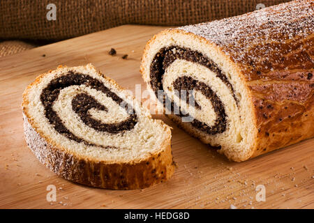 Tradizionale ungherese torta folk xmas poppy rotoli su un tagliere di legno Foto Stock