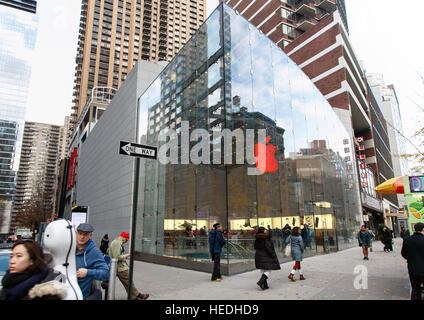 Le persone sono a piedi da Apple Store su Broadway e West 67th Street. Il logo del negozio è illuminato in rosso. Foto Stock