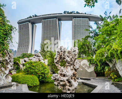 Singapore, roccia scolpita in giardini dalla baia contro lo sfondo della Marina Bay Sands Resort Foto Stock