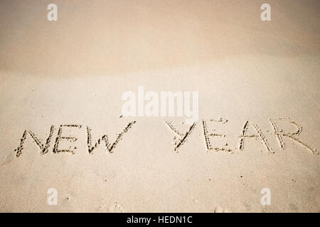 Felice Anno Nuovo scritto nella sabbia bianca Foto Stock