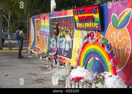 Un passerby smette di leggere omaggi a sinistra un memoriale di fortuna intorno al nightclub di impulsi 18 Dicembre 2016 a Orlando, Florida. Il 12 Giugno 2016 49 persone sono state uccise e 53 ferite in più letali riprese di massa mediante un unico pistolero nella storia degli Stati Uniti e più letali attacchi terroristici sul suolo americano dopo gli eventi dell'11 settembre 2001. Foto Stock