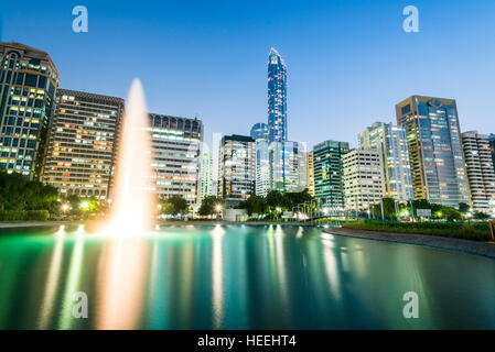 Abu Dhabi Corniche catturati al tramonto con riflessi in un lago Foto Stock