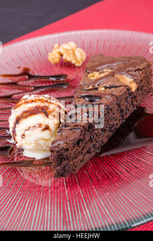 Cuneo di cioccolato torta di noci servita con gelato e guarnita con lo sciroppo al cioccolato Foto Stock