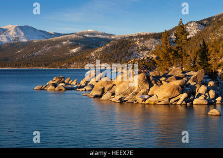 Sand Harbor, Lake Tahoe, Nevada al tramonto con rocce e alberi sulla battigia.