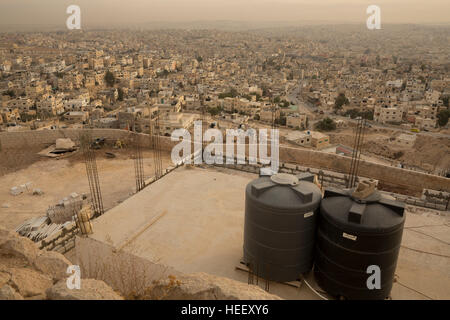 Serbatoi di stoccaggio dell'acqua a sedersi su un tetto a Zarqa, Giordania. Foto Stock