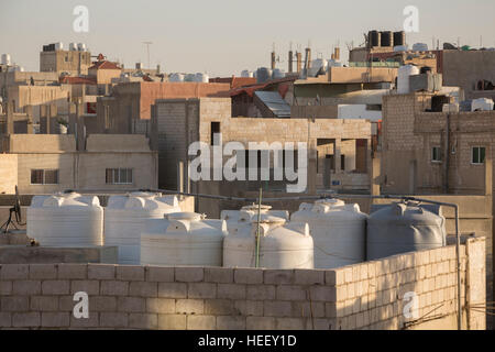 Serbatoi di stoccaggio dell'acqua a sedersi su un tetto a Zarqa, Giordania. Foto Stock