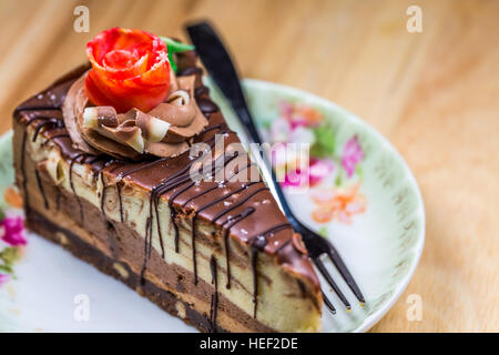 Fette di torta al cioccolato su un tavolo di legno sfondo Foto Stock