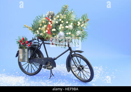 Biciclette giocattolo con decorazioni di Natale su sfondo blu Foto Stock