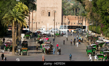 Carrozze trainate da cavalli in attesa intorno Moschea Koutoubia per turisti. Marrakech, Marocco. Foto Stock