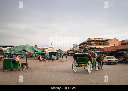 Marrakech, Marocco - Dicembre 2016: la gente sulla molto trafficata piazza principale di Marrakech in Marocco chiamato Jeema el Fna, con cibo severel e succo di stand Foto Stock