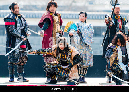 Yosakoi giapponese festival. Danzatori vestiti come il samurai warriors, esecuzione di breve mostra sul palco con il Castello di Kumamoto in background. Foto Stock