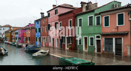 Case colorate da Canal con le barche a motore durante la pioggia, Burano, Venezia, Veneto, Italia Foto Stock