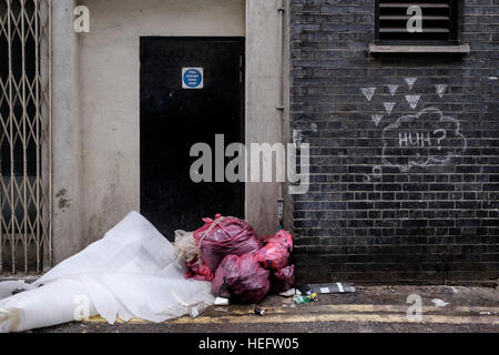 Volare con punta di rifiuti su una Londra back street. Non è chiaro il graffito è collegato ma rende un interessante immagine Foto Stock