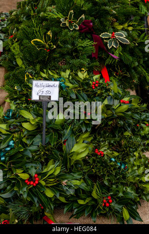 Holly ghirlande per la vendita a Natale Street Market, Lewes, Sussex, Regno Unito Foto Stock