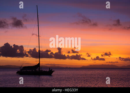 Mare splendido tramonto in Australia Whitsunday, con blood red sky e una silhouette in barca Foto Stock