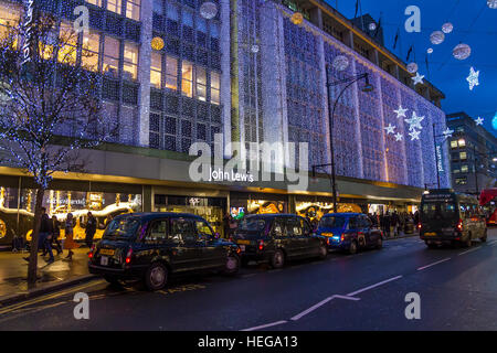 Una linea di taxi londinesi neri fuori dal John Lewis Department Store su Oxford St di Londra al tempo di Natale, Londra, Regno Unito Foto Stock