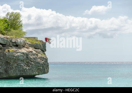 Curacao, Caraibi - ottobre 1, 2012: Turistica saltando dal rock al Grand Knip Beach a Curacao in Antille Olandesi, isola dei Caraibi. Phot Foto Stock