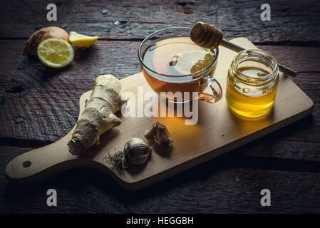 Le medicine naturali contro la canna fumaria e freddo. Il miele, limone e aglio. Salute e medicina alternativa concetto. Foto Stock