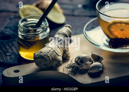 Le medicine naturali contro la canna fumaria e freddo. Il miele, limone e aglio. Salute e medicina alternativa concetto. Foto Stock