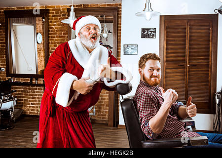 Santa Claus come master al Barber shop Foto Stock