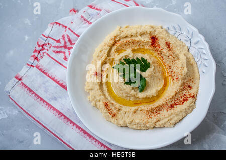 Home classic hummus con sedano, pita. Vista dall'alto sul cemento grigio Sfondo. Cibo Vegan concetto. Foto Stock