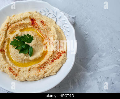 Home classic hummus con sedano, pita. Vista dall'alto sul cemento grigio Sfondo. Cibo Vegan concetto. Foto Stock