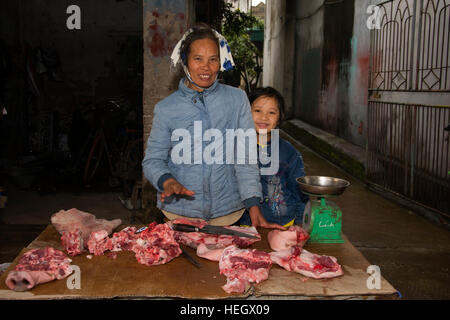 ASIA, Vietnam, Hai Duong Provincia, Thanh ha Village, Donna con bambina, la vendita di carne alla pressione di stallo Foto Stock