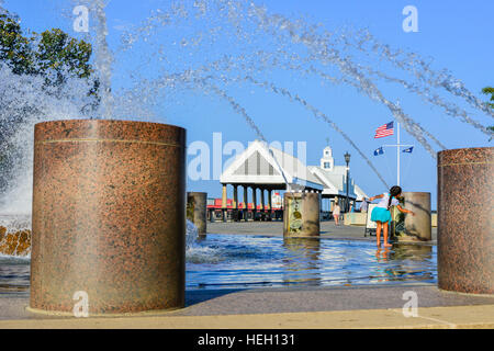 Bambina gioca nella fontana di acqua in un paesaggistico Riverfront Park lungo il fiume Cooper e Vendue Wharf in Charleston SC Foto Stock