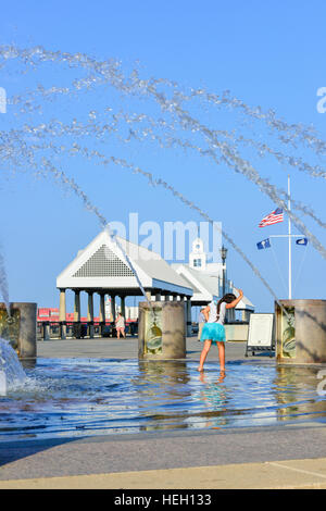 Bambina gioca nella fontana di acqua in un paesaggistico Riverfront Park lungo il fiume Cooper e Vendue Wharf in Charleston SC Foto Stock