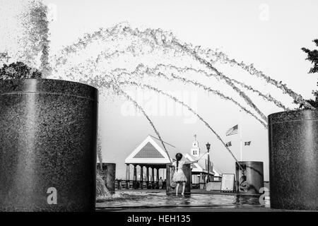 Bambina gioca nella fontana di acqua in un paesaggistico Riverfront Park lungo il fiume Cooper e Vendue Wharf in Charleston SC Foto Stock