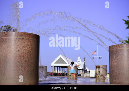 Bambina gioca nella fontana di acqua in un paesaggistico Riverfront Park lungo il fiume Cooper e Vendue Wharf in Charleston SC Foto Stock