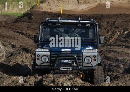 Un Land Rover Defender 90 bloccato nel fango spesso durante una dura 4x4 off road challenge Foto Stock