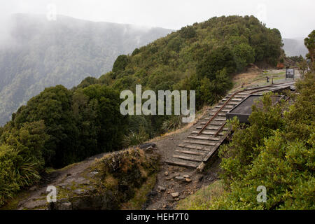 Binari arrugginiti e vecchi vagoni rimangono dalla pendenza Denniston quale carbone trasportato da un misuratore 600 altopiano fino alla costa. Foto Stock