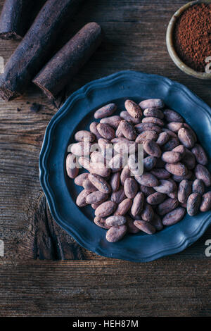 Cacao grezzo in tre diverse forme, come chicchi di cacao, bastoni e polvere Foto Stock