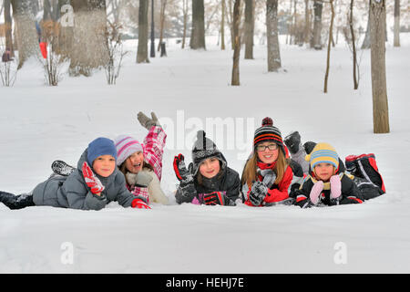 Dei bambini felici in winterwear ridere mentre giocando in posizione di parcheggio Foto Stock