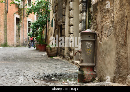 Acqua potabile in esecuzione da un tap sulla vecchia strada di Roma, Italia Foto Stock