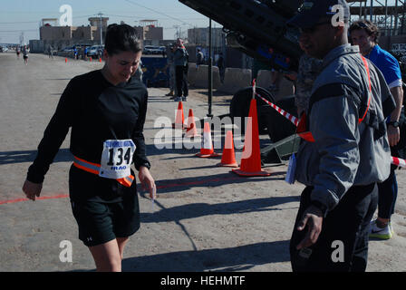 Stati Uniti Esercito 1Lt. Kathryn Walker di Iowa City, Iowa, assegnato al settantesimo ingegneri, ingegnere 555th brigata, Divisione Multinazionale a Bagdad, dolorosamente finisce un venticinquesimo divisione di fanteria sponsorizzato maratona il Camp Taji, Iraq, 14 dicembre. Maratona di Honolulu tenutasi il Camp Taji 138453 Foto Stock